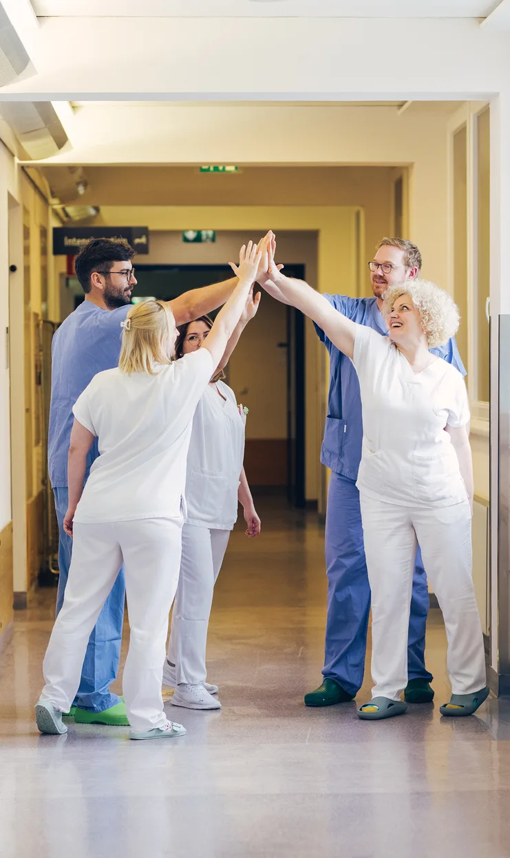 Clinical and nursing staff of Barmherzige Brüder Wien celebrating together in a hospital corridor